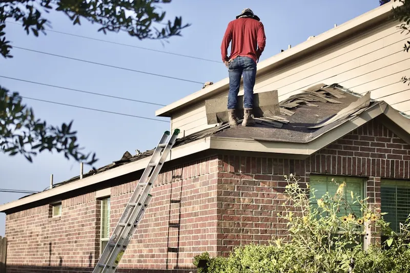 Professional roofer working on a residential roof in McMoran Park
